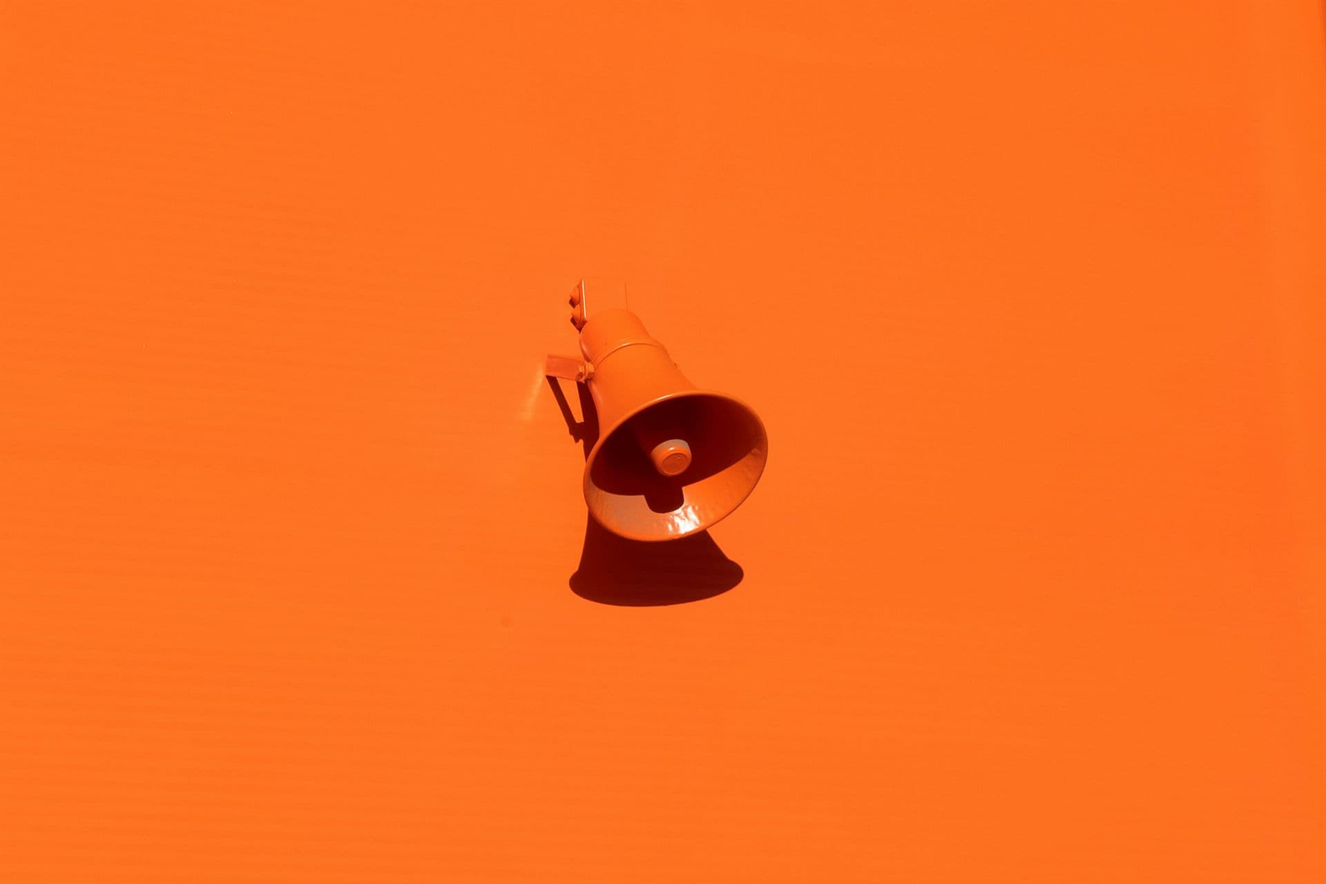 An orange megaphone on an orange background